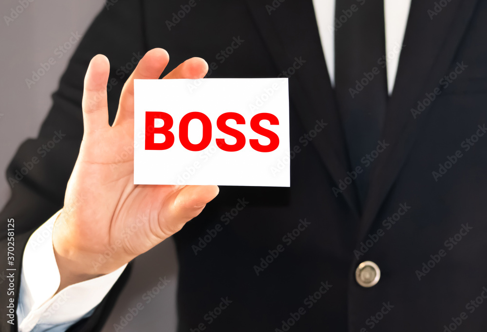 Businessman shows a card with word BOSS. CEO or general manager business concept. Businessman shows a card with word BOSS. CEO or general manager business concept.