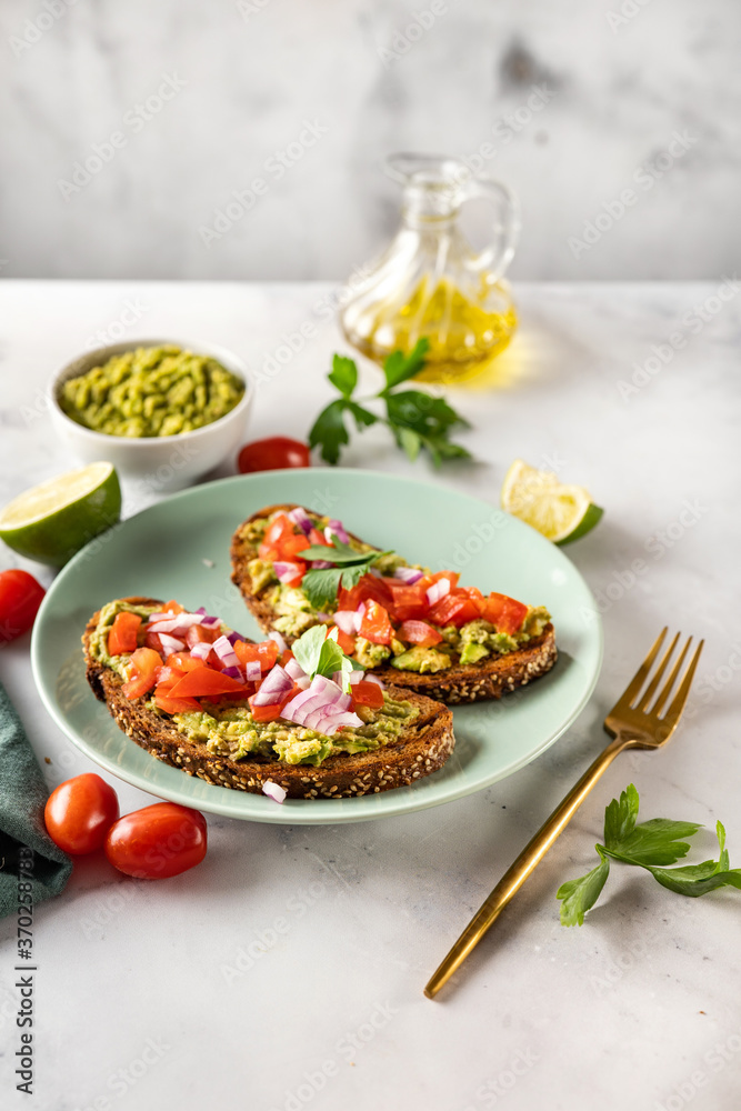 Vegan helathy avocado toast with tomatoes and parsley Vegan helathy avocado toast with tomatoes and parsley
