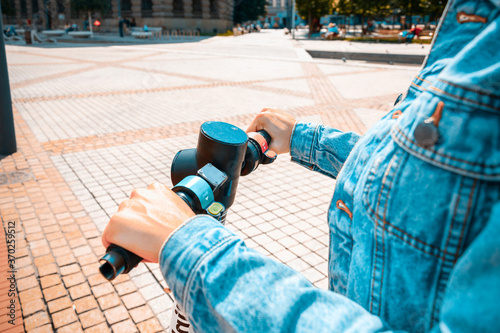 City scooter. Kick electric bike using from business woman. Public mobile transportation in European city center.