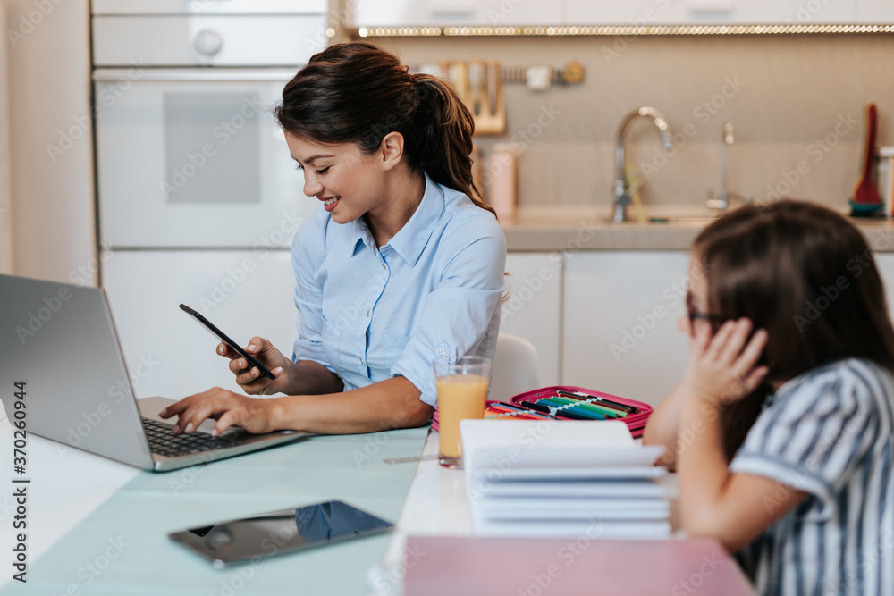 Beautiful young mother helping her younger daughter with homework. Beautiful young mother helping her younger daughter with homework.