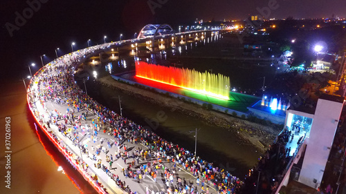 Aerial view of nighttime fountain attraction at Surabaya bridge, East Java, Indonesia which attracts local tourists
