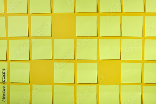 a lot of light yellow stickers for notes on yellow background  brainstorming concept
