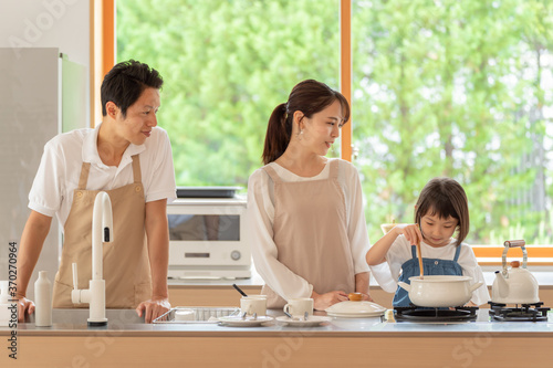 キッチンで料理を作る女の子と両親 © taka