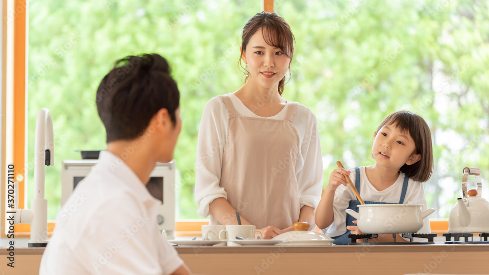 キッチンで料理を作る女の子と両親 キッチンで料理を作る女の子と両親