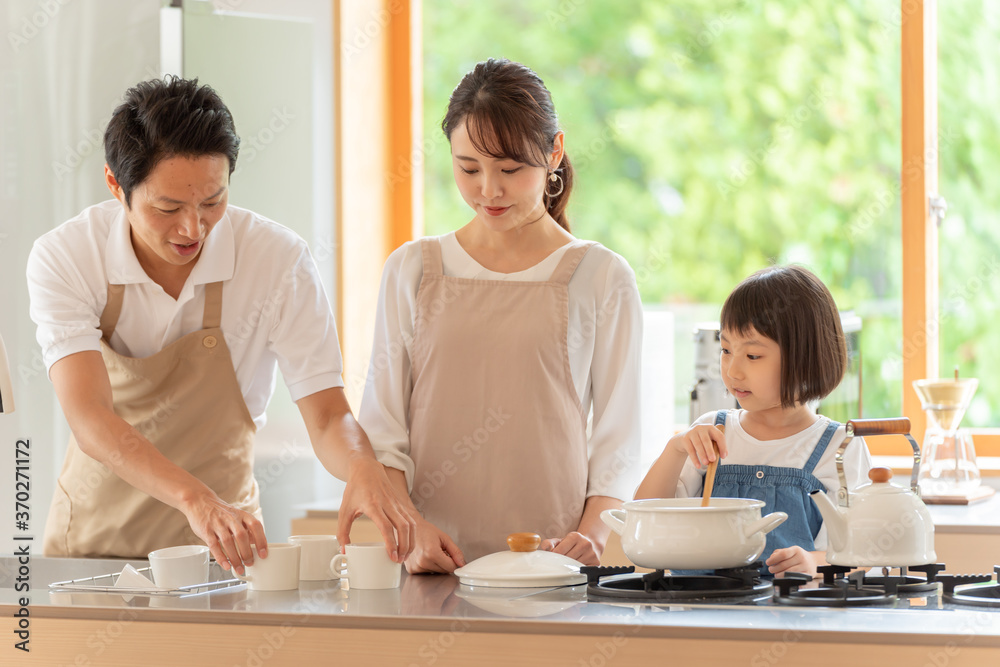 キッチンで料理を作る女の子と両親