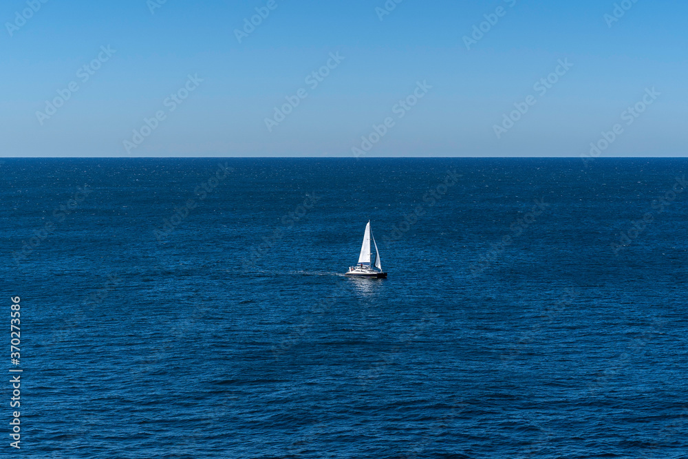 Seascape of the beautiful blue ocean/ sea with a Yacht Sailing in the sea