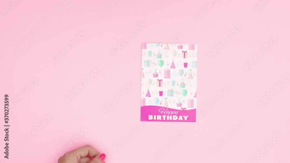 Woman hand put birthday greeting card and gift on pink theme. Stop motion Woman hand put birthday greeting card and gift on pink theme. Stop motion