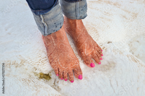 Obraz na płótnie Indian tourist feet decorated with henna on white stone made by carbonate mineral left by the hot flowing waters w salonie
