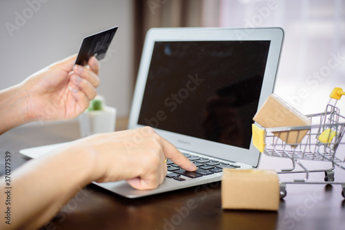 Hand holding a credit card and having a laptop concept, online shopping