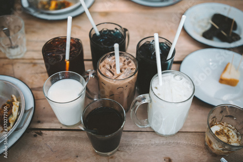 Glasses of various beverages placed on a wooden table