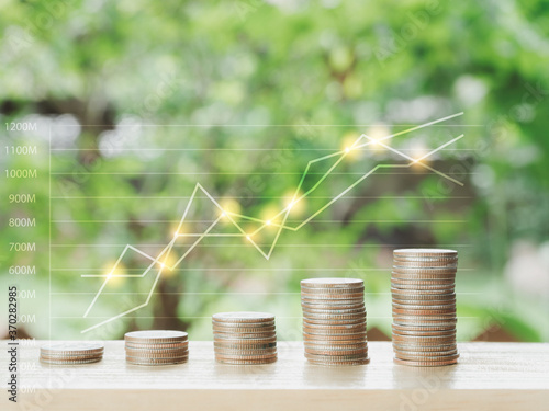 Coins stack on wood table on nature background. Finance saving money and environment concept