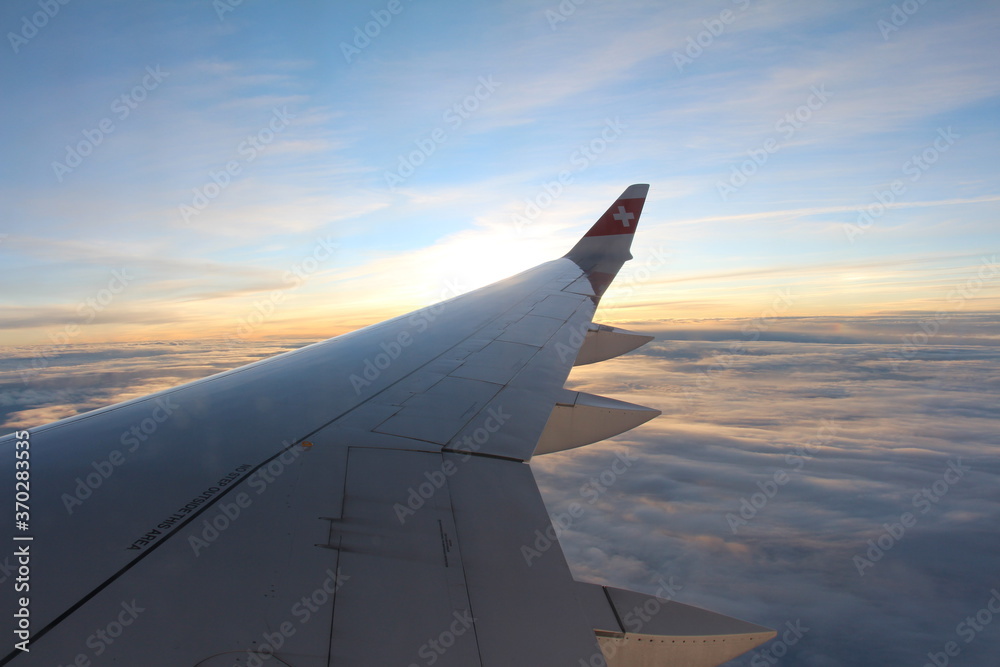 Obraz premium wing of airplane at sunset