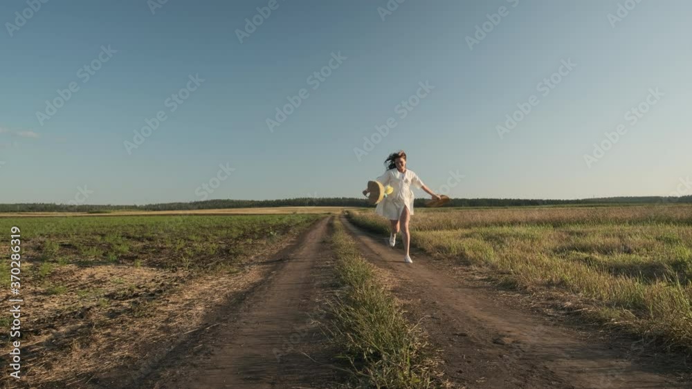 A girl in light clothes in the summer in the evening walks and rests in a field with ears of wheat A girl in light clothes in the summer in the evening walks and rests in a field with ears of wheat