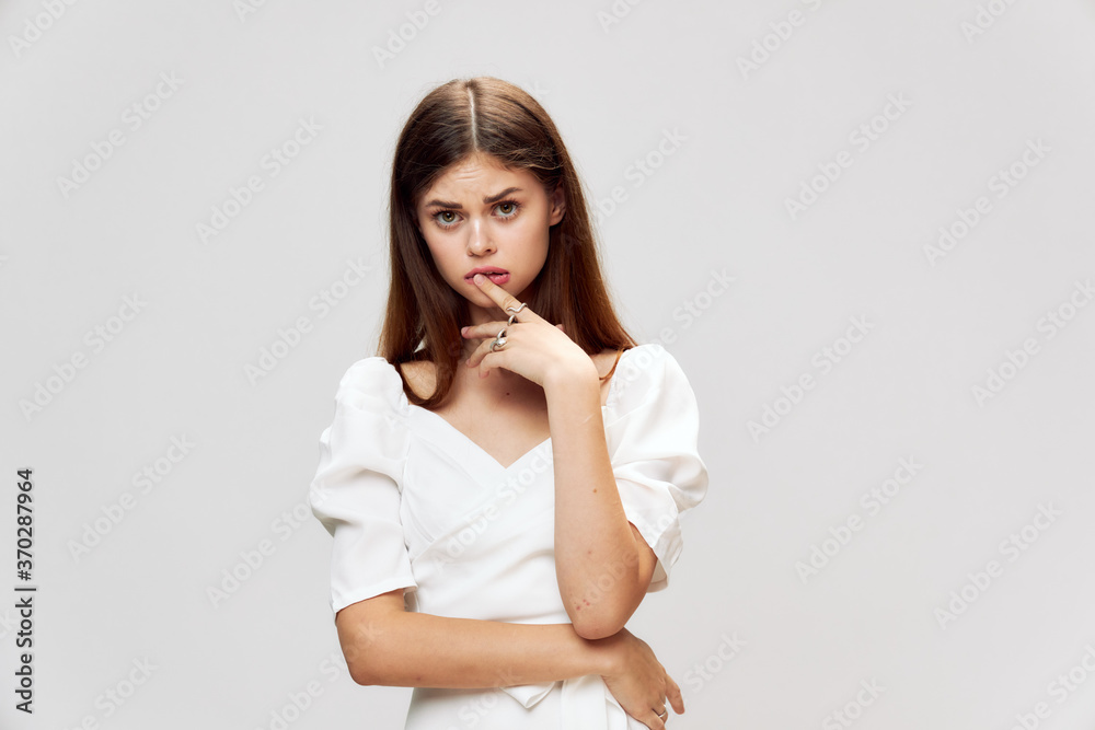 Girl holding a finger on her lips white dress cropped view Girl holding a finger on her lips white dress cropped view