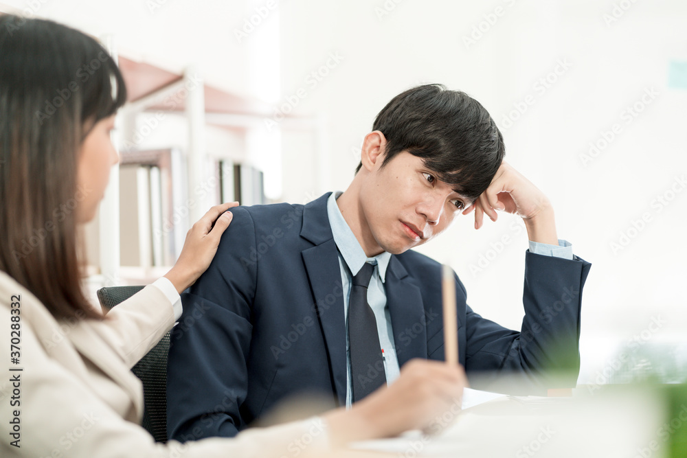 Asian business people having a casual discussion. Staff sitting and discussing work in office. Asian business people having a casual discussion. Staff sitting and discussing work in office.
