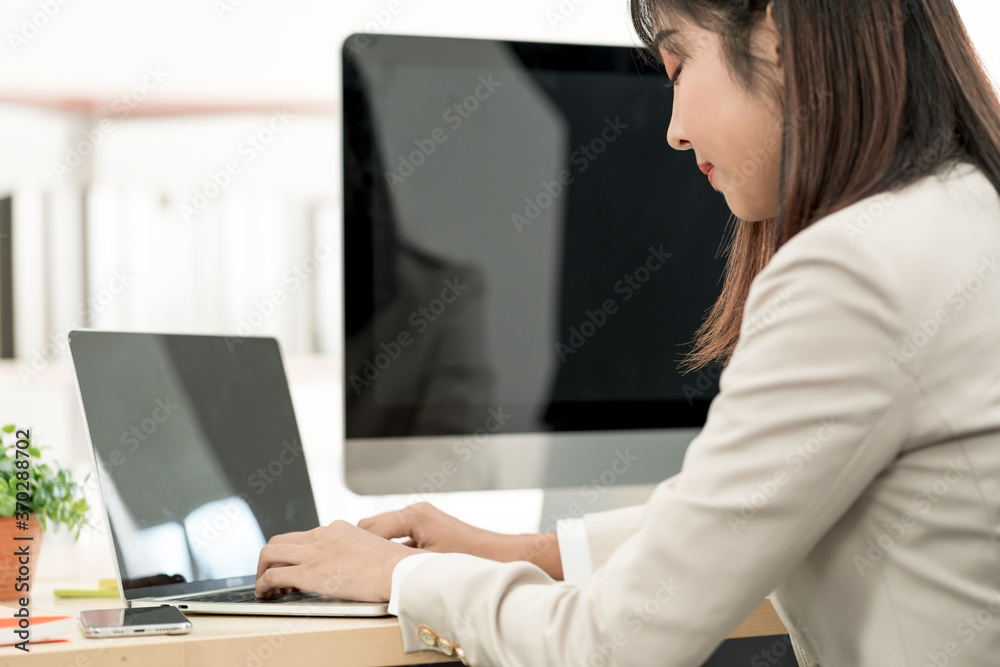 Asian business woman working at her office via laptop. Young female manager using computer at workplace Asian business woman working at her office via laptop. Young female manager using computer at workplace