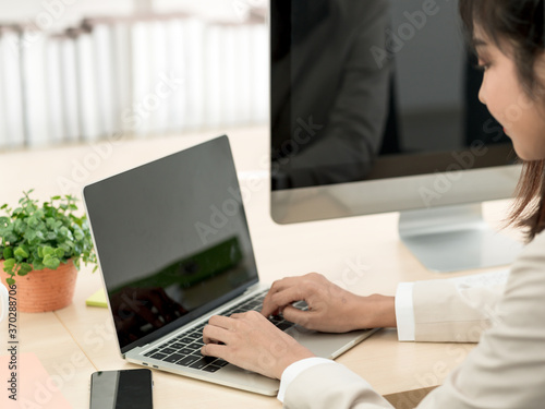 Asian business woman working at her office via laptop. Young female manager using computer at workplace