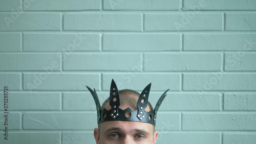 closeup. male head in a black leather crown on a brick wall background
