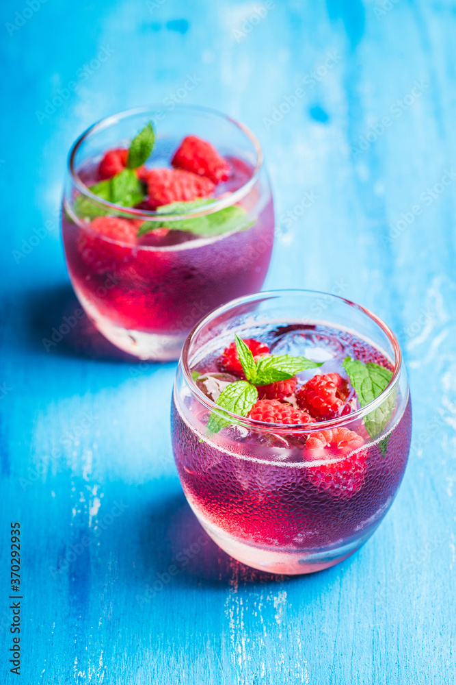 Raspberry and mint cocktail in glass on the rustic background. Selective focus. Shallow depth of field.
