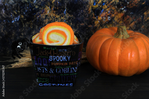 Candy corn swirl cookies in a Halloween container.  Low light