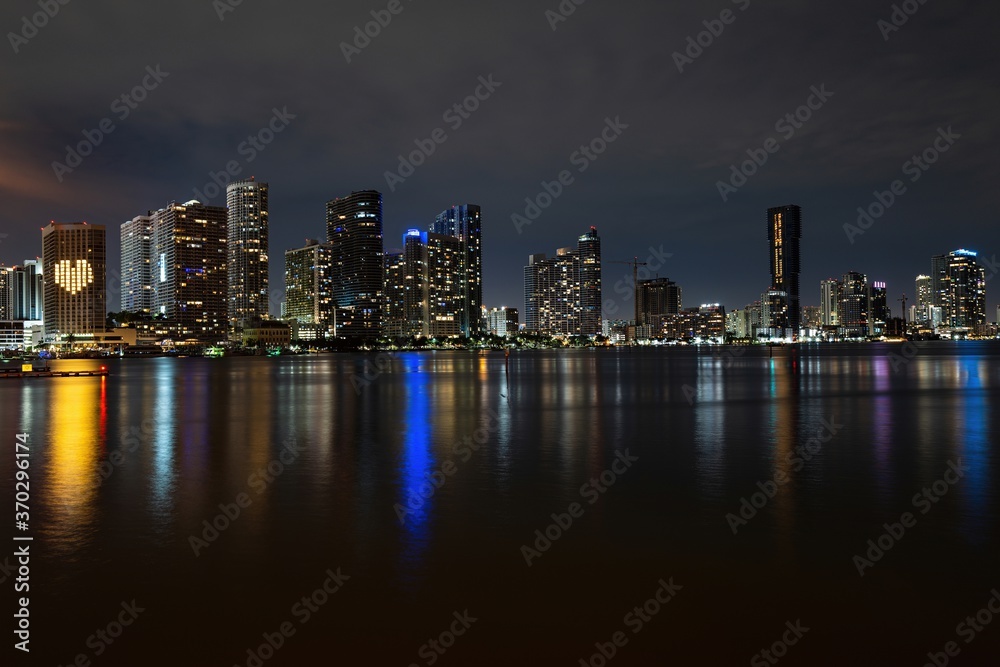 Miami night. Miami Florida, sunset panorama with colorful illuminated business and residential buildings and bridge on Biscayne Bay.