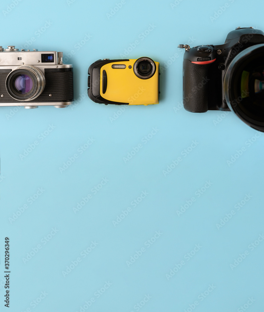 Camera evolution.Cameras of different types and generations on a blue background, top view,flat lay.