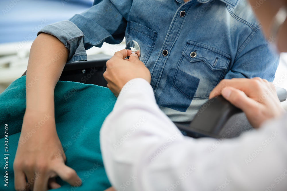 Asian doctor use stethoscope checkup  disability wheel chair patient  person