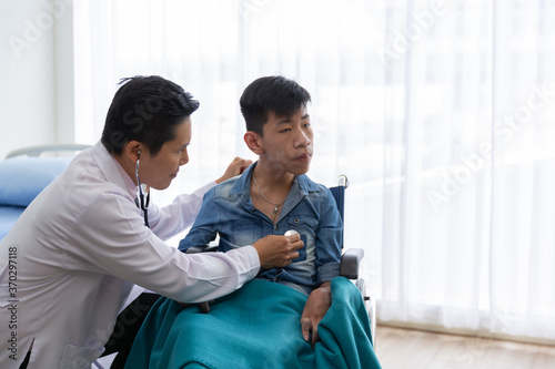 Asian doctor use stethoscope checkup  disability wheel chair patient  person