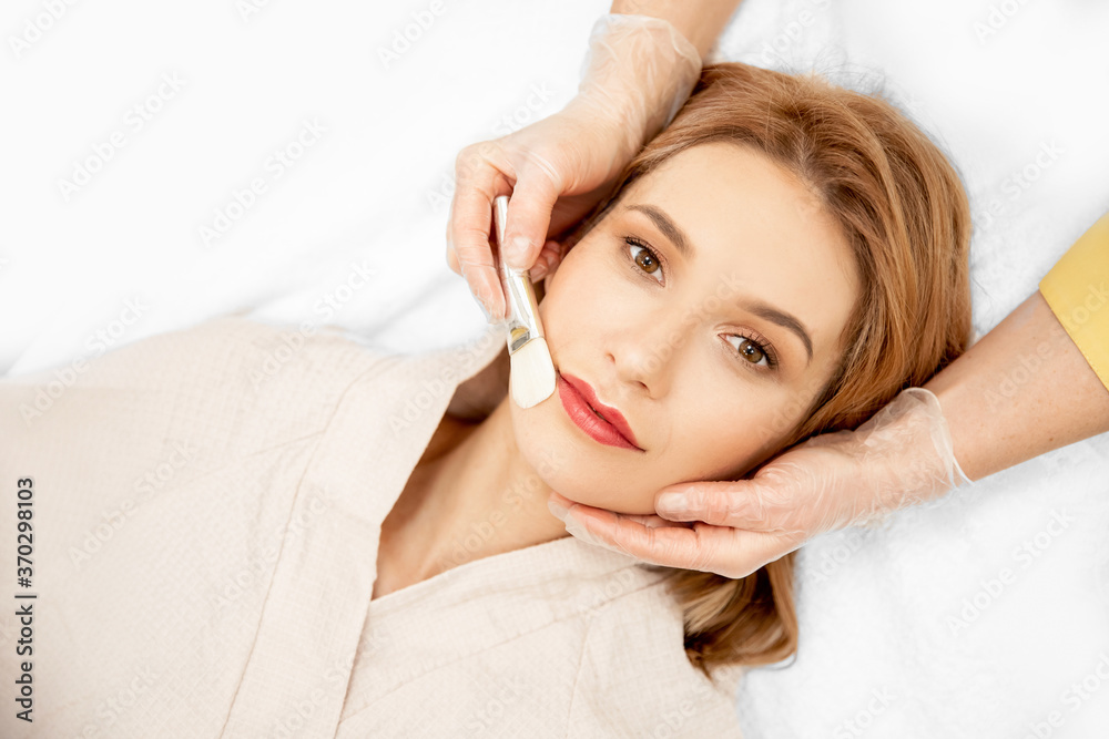 Fototapeta premium Doctor use brush applying cream to skin care and cosmetics concept. Woman face natural makeup