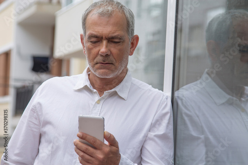Wallpaper Mural senior man using mobile phone in the city Torontodigital.ca