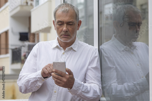 senior man using mobile phone in the city © tetxu