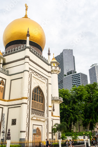 Singapore. Historical old Sultan Mosque in Kampong Glam Arabic district in Singapore, with golden dome and modern cityscape of Singapore in the background.