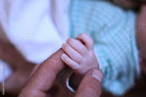 child's hand holding father's finger © Artem