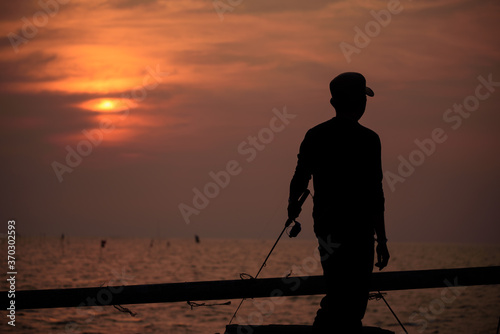 The fisherman silhouette with sunset sky