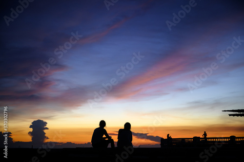 The people silhouette at the sea with sunset sky