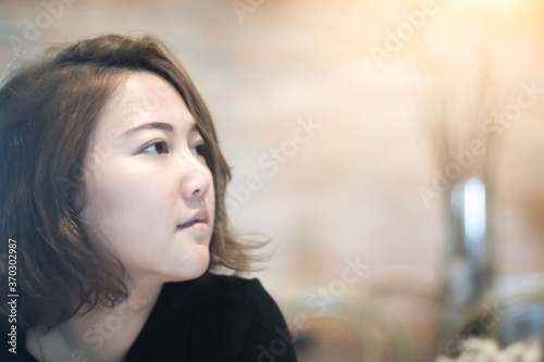 portrait of a young beautiful Asian woman with sunlight in cafe.