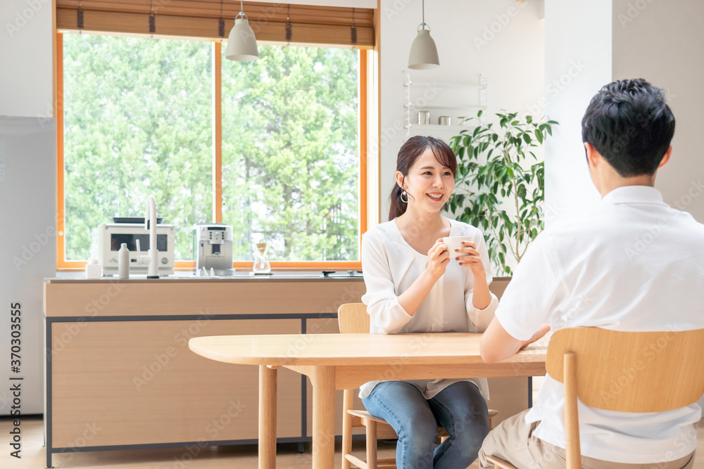 リビングで話す若い夫婦・カップル リビングで話す若い夫婦・カップル