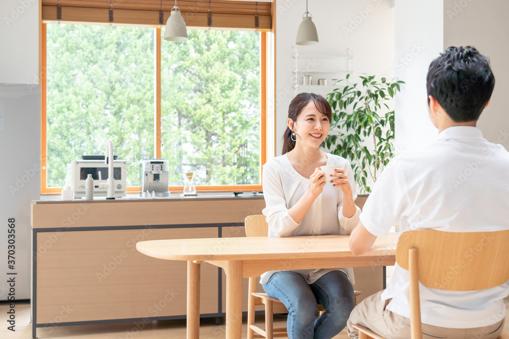 リビングで話す若い夫婦・カップル リビングで話す若い夫婦・カップル
