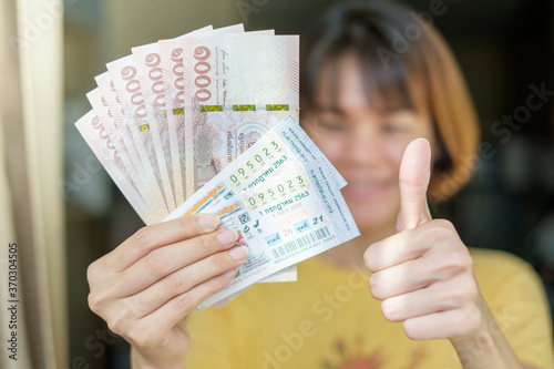 BANGKOK, THAILAND - July 5: Ladprao condo on July 5,2020 in Bangkok, Thailand. Lucky Woman holding Thai lottery with banknote for winner