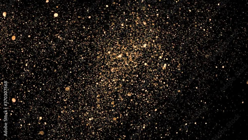 Golden glitter sand or dust creating abstract cloud formations metamorphosis. Art backgrounds. 
