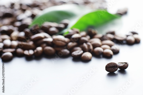 Bag of coffee. Coffee beans roasted on the table. Coffee beans with green leaves for cooking.