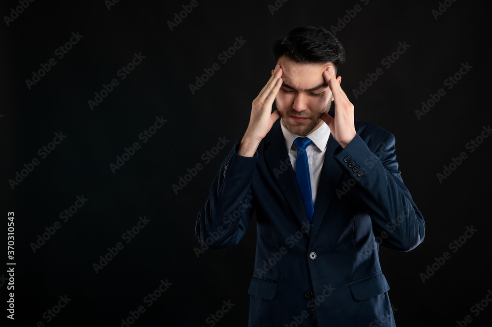 Portrait of business man wearing blue business suit and tie gesturing head ache