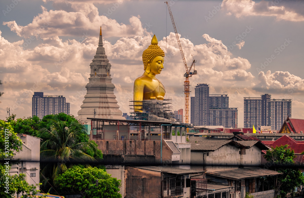 Fototapeta premium Close-up natural background of the waterfront community, a large Buddha statue (Wat Paknam Phasi Charoen) stands beautifully, seen in tourist attractions in Bangkok, Thailand.