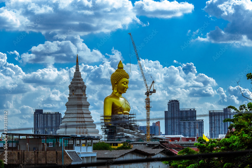 Fototapeta premium Close-up natural background of the waterfront community, a large Buddha statue (Wat Paknam Phasi Charoen) stands beautifully, seen in tourist attractions in Bangkok, Thailand.