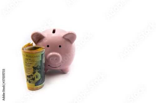 Pink piggy bank with golden crown and stack of Australian 50 dollars banknotes in front isolated over white background with copy space, cash is king concept image photo