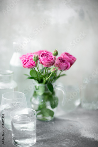 bouquet of purple garden roses in a glass jug