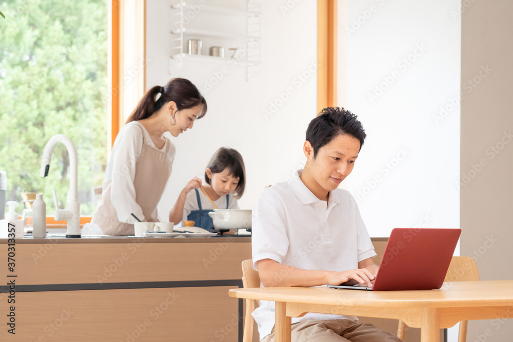 家でテレワークする男性と家族 家でテレワークする男性と家族