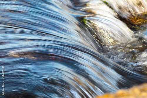 water flowing over rocks , motion blur of fast moving wave.