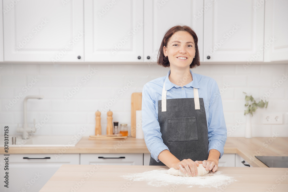 Young woman housewife prepares dough on background of light kitchen, fresh pizza Young woman housewife prepares dough on background of light kitchen, fresh pizza