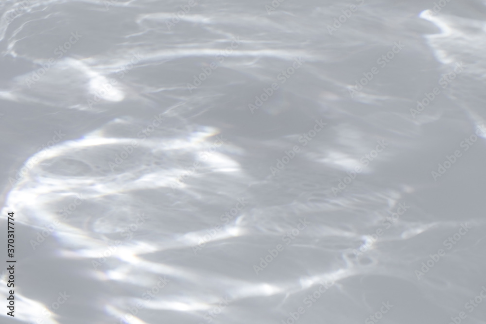 Obraz premium Blurred water texture overlay effect for photo and mockups. Organic drop diagonal shadow and light caustic effect on a white wall. Shadows for natural light effects